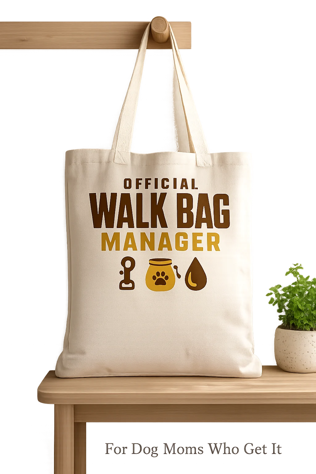 Official Walk Bag Manager tote displayed against a neutral wall on a bench with one small plant